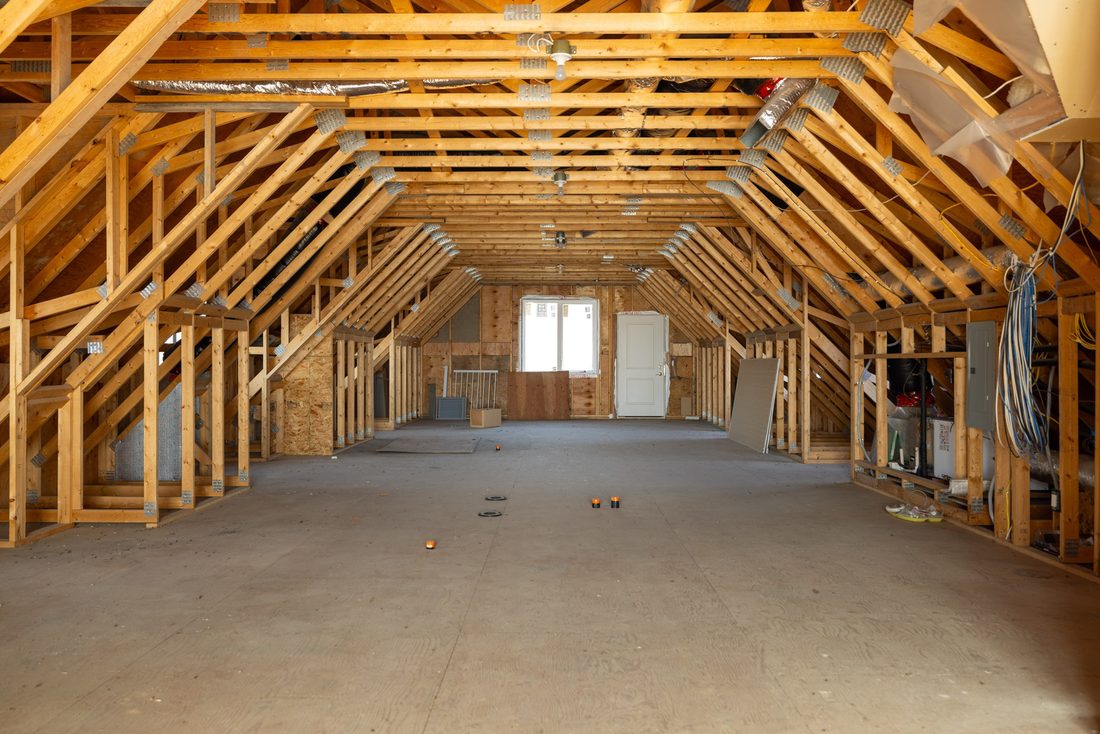 The unfinished upper room above the garage wing, vaulted, with exposed timber trusses